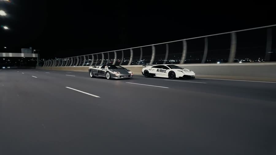 Two No Merci liveried cars on a motorway at night